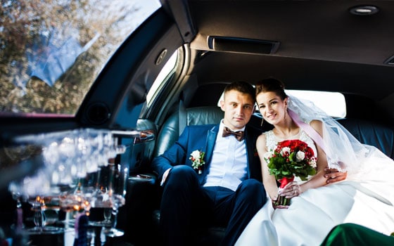 Bride and groom seated together inside a wedding car